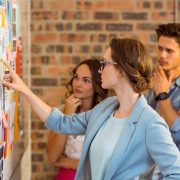 A group analyzing notes on a wall for project planning.