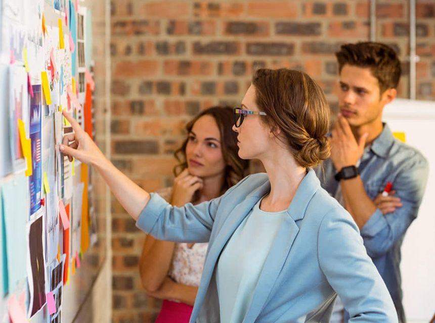 A group analyzing notes on a wall for project planning.