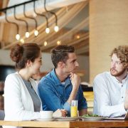 Three colleagues discussing work in a modern office setting.