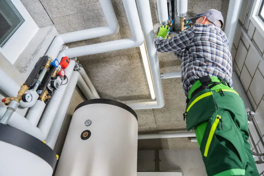 Worker fixing pipes in a boiler room.